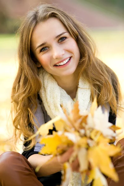 Mujer sosteniendo hoja de otoño — Foto de Stock