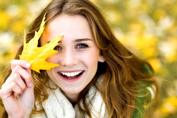 Mujer sosteniendo hoja de otoño — Foto de Stock