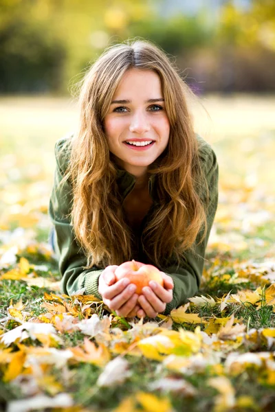 Donna che mangia mela all'aperto in autunno — Foto Stock