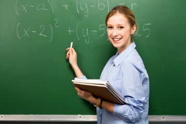 kız öğrencinin matematik kara tahta üzerinde yapıyor