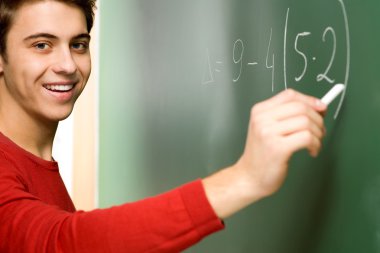 Kara tahta üzerinde matematik yapıyor öğrenci