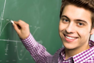 Kara tahta üzerinde matematik yapıyor öğrenci