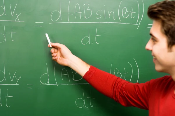 Estudiante haciendo matemáticas en pizarra — Foto de Stock