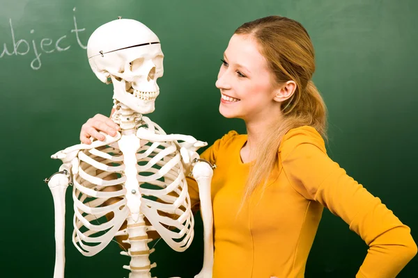 Vrouwelijke student met skelet — Stockfoto