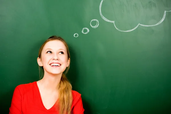 Woman standing next to thought bubble on blackboard Stock Photo