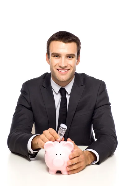 Empresario poniendo dinero en alcancía — Foto de Stock