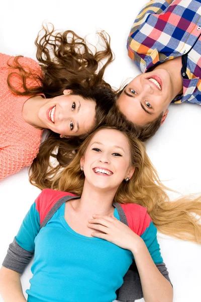 Three young friends lying down — Stock Photo, Image