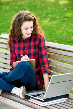 Kız onun ödev açık havada yapıyor