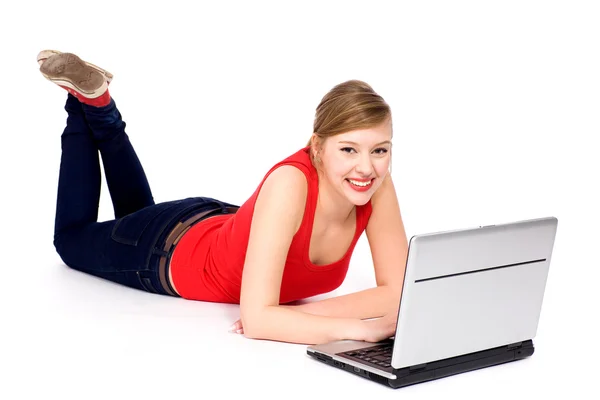 Meisje liggen met laptop Stockfoto