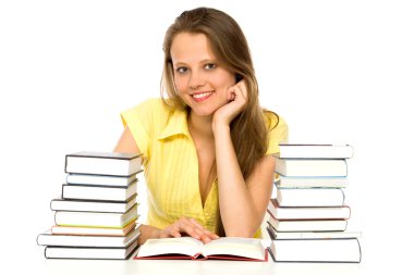 kitap yığınları ile bir masada oturan genç kadın