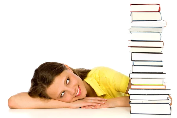 Jeune femme regardant pile de livres — Photo