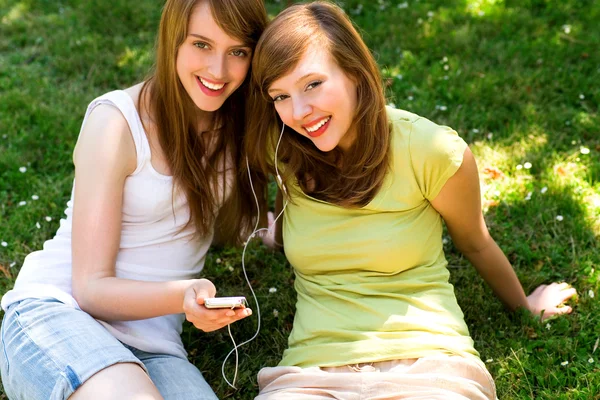 Jonge vrouwen luisteren naar mp3-speler — Stockfoto