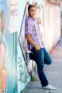 genç adam grafiti duvara yaslanmış