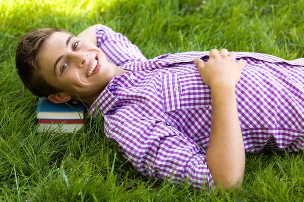 Человек лежит на траве с книгой — стоковое фото