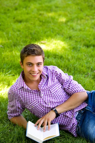 Man lying on grass with book — Stock Photo, Image