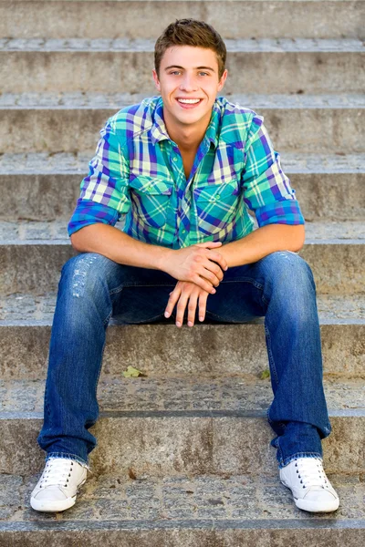 Young man sitting on stairs — Stock Photo, Image