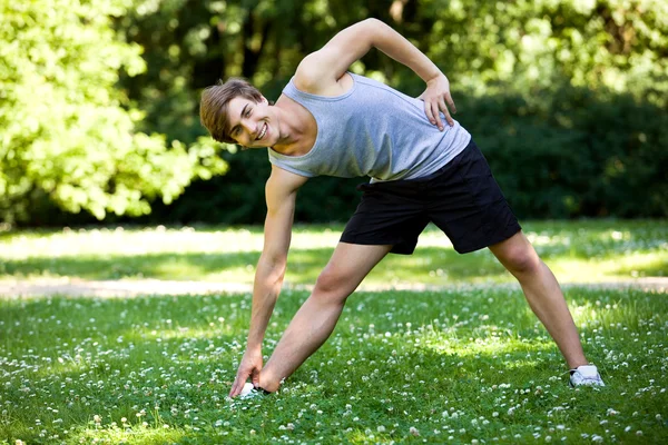 Mladý muž cvičení v parku — Stock fotografie
