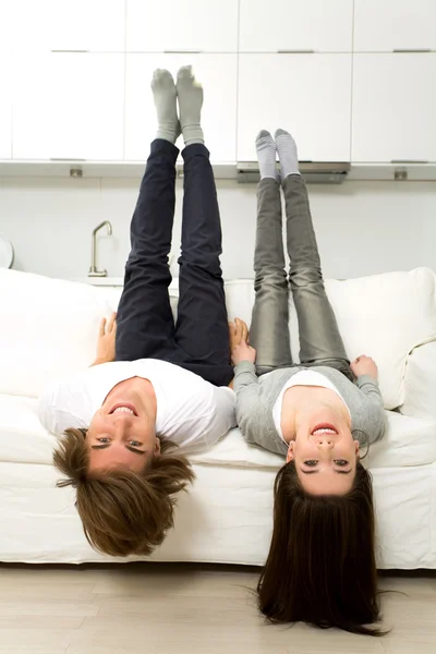 Paar kopfüber auf Sofa lachend — Stockfoto
