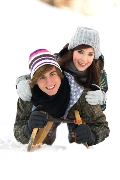 Ungt par på släde i snö — Stockfoto