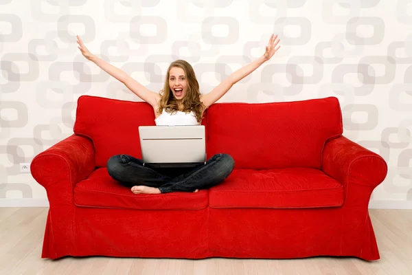 Woman sitting on couch with laptop — Stock Photo, Image