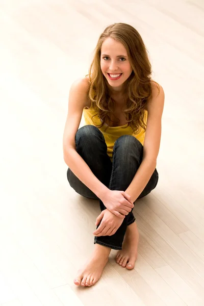 Young woman sitting on floor — Stock Photo, Image