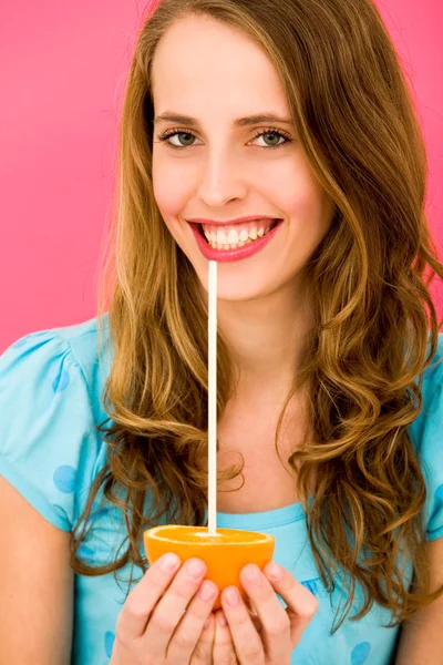 Mujer sosteniendo naranja con paja — Foto de Stock