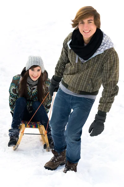 Man pulling woman on sled — Stock Photo, Image