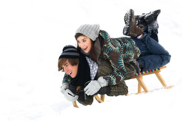 Young couple on sled in snow — Stock Photo, Image