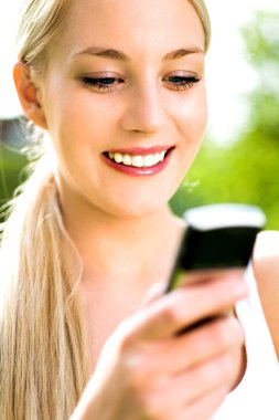 açık havada cep telefonu kullanan kadın