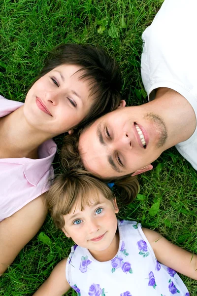 Family outdoors lying on grass — Stock Photo, Image