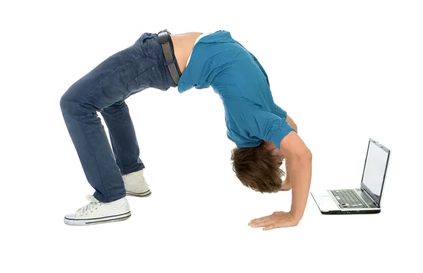Young man bending over backwards while using laptop — Stok fotoğraf