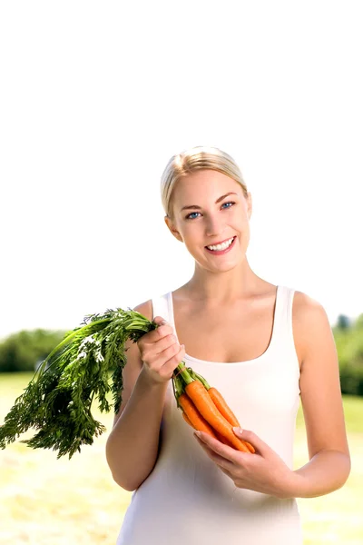 Femme tenant un tas de carottes — Photo