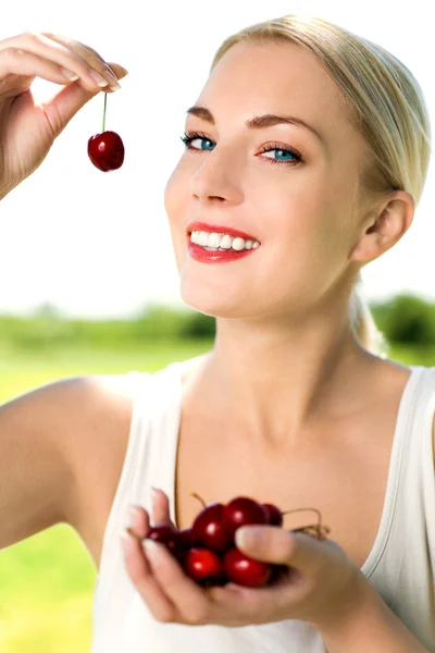 Woman eating cherries — Stock Photo, Image