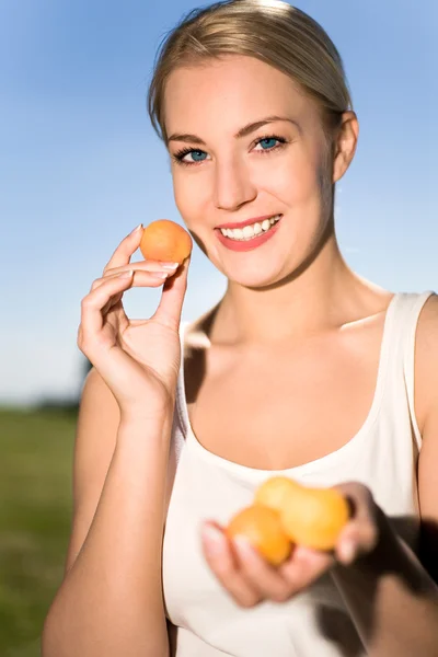 Junge Frau mit Aprikosen — Stockfoto