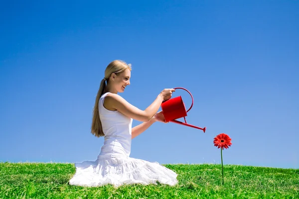 Jeune femme arrosage fleur — Photo