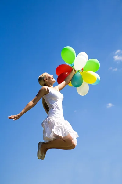 Femme sautant avec des ballons — Photo