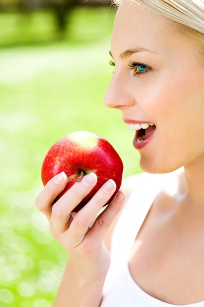 Kvinnan håller ett äpple i handen — Stockfoto