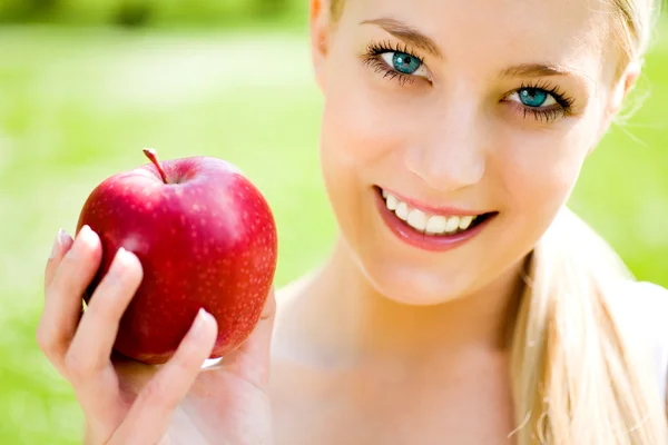 Woman holding an apple in her hand — Stock Photo, Image