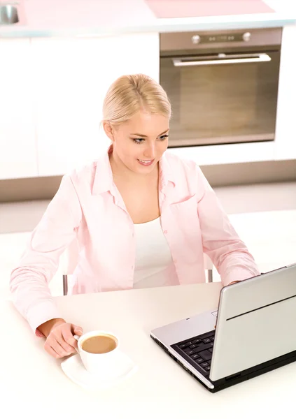 Vrouw in keuken met laptop — Stockfoto