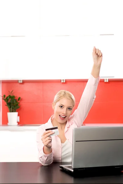 Vrouw in keuken met laptop en credit card — Stockfoto