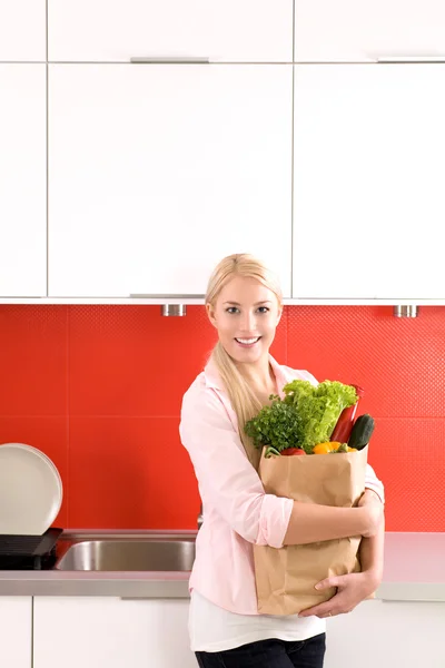 Mujer con bolsa de supermercado en cocina — Stockfoto