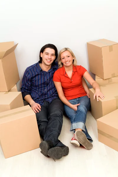 Casal no chão ao lado de caixas móveis — Fotografia de Stock