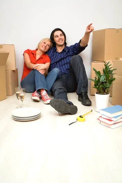 Casal no chão ao lado de caixas móveis — Fotografia de Stock