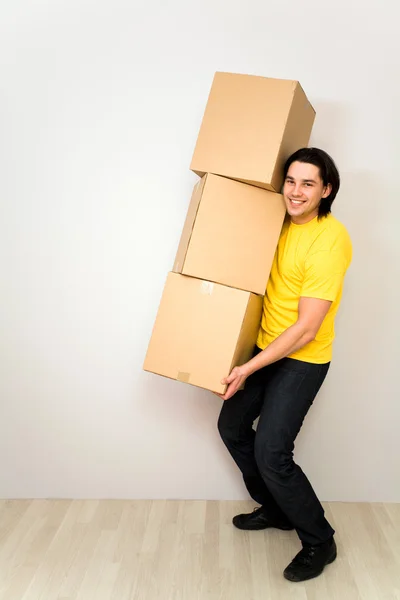 Joven hombre llevando cajas — Foto de Stock