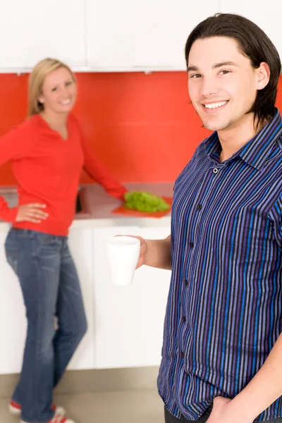 Casal na cozinha, homem segurando xícara de café — Fotografia de Stock