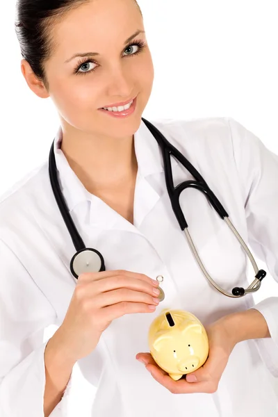 Doctor putting money in a piggy bank — Stock Photo, Image