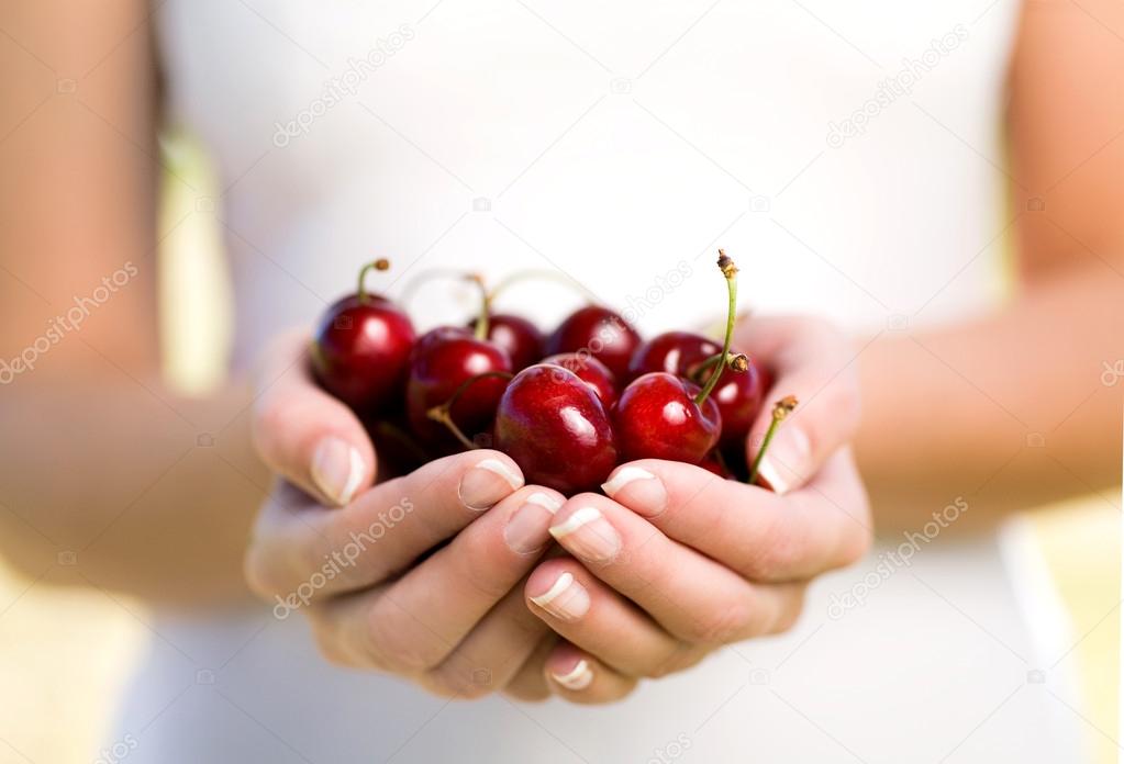 Hands full of cherries