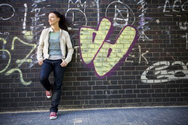 grafiti ile tuğla duvara yaslanmış kadının