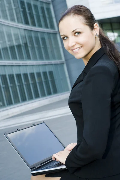 Businesswoman using laptop outside office — Stock Photo, Image