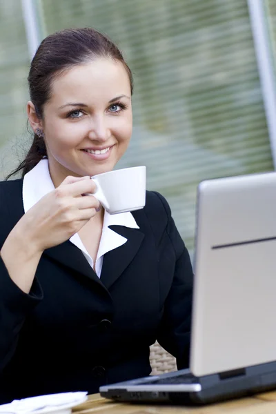 Frau mit Laptop trinkt Kaffee — Stockfoto